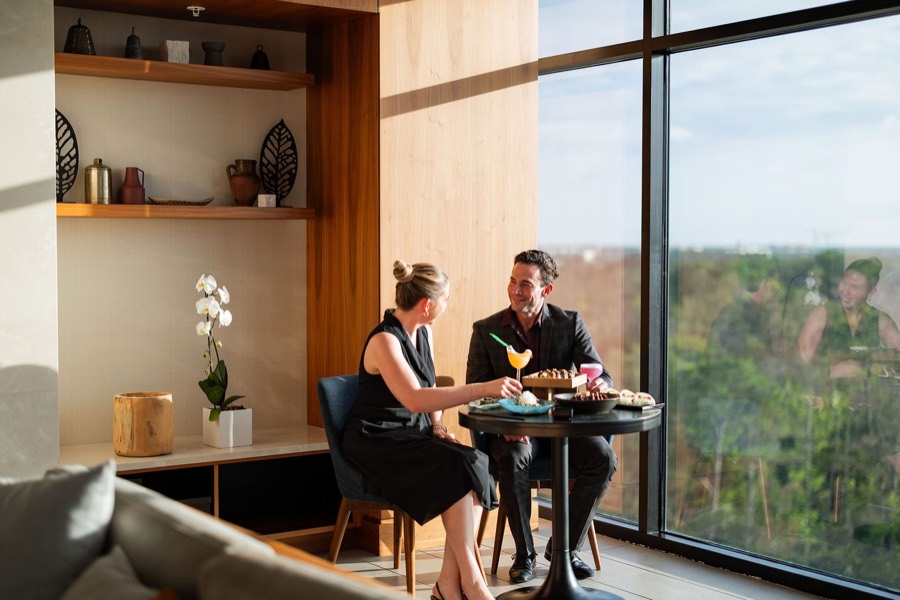 Guests at a window table at illume Rooftop Lounge